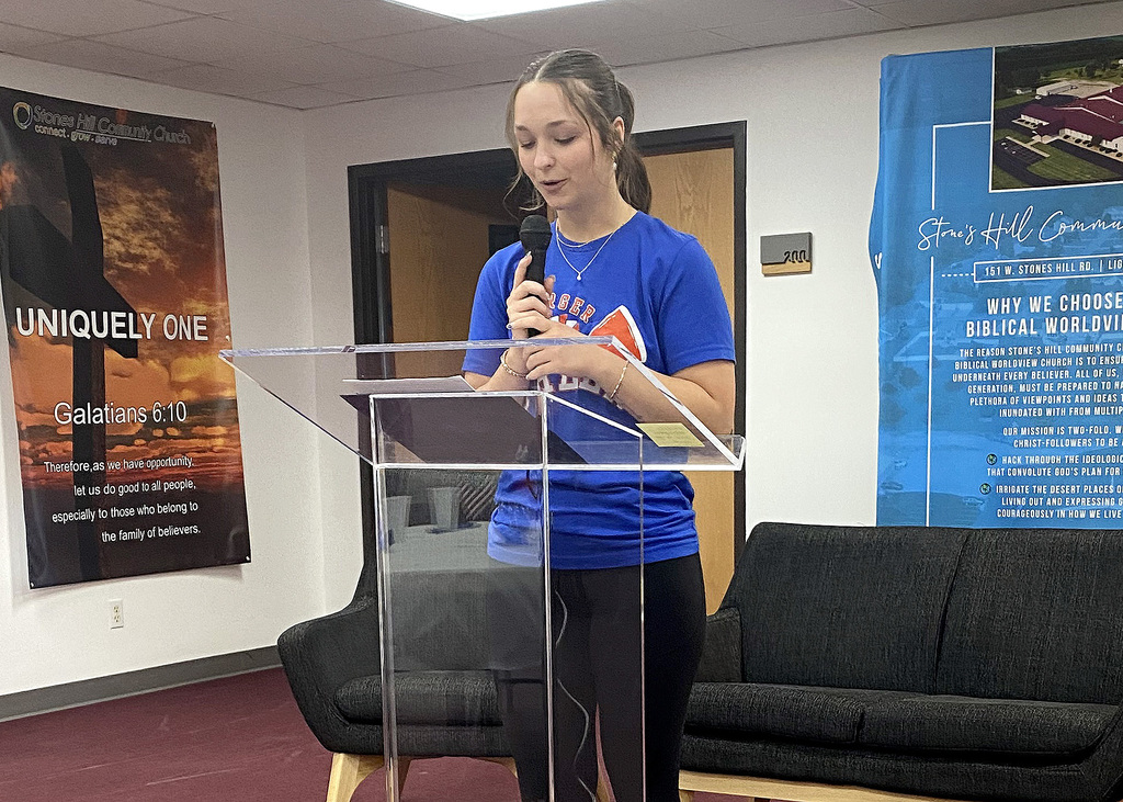 student reading a story at a podium