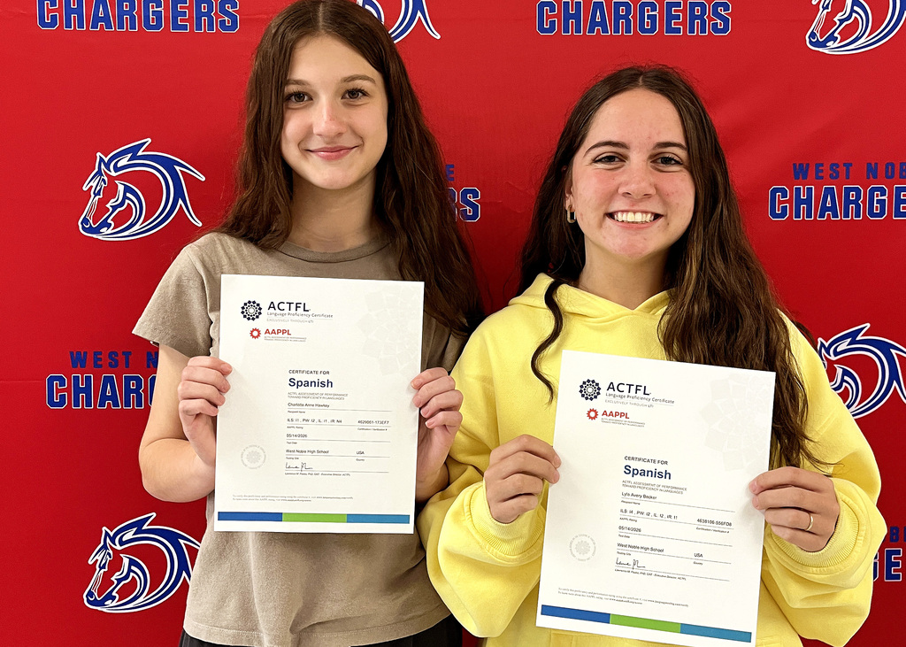two girls holding paper certificates