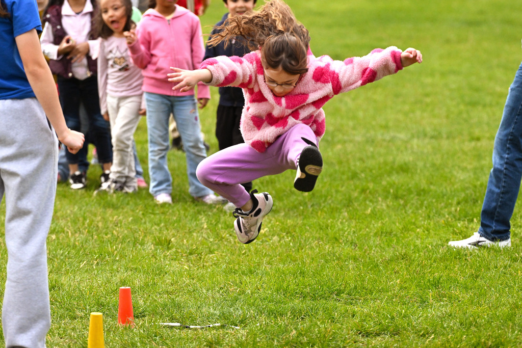 a girl flying through the air at a long jump pit