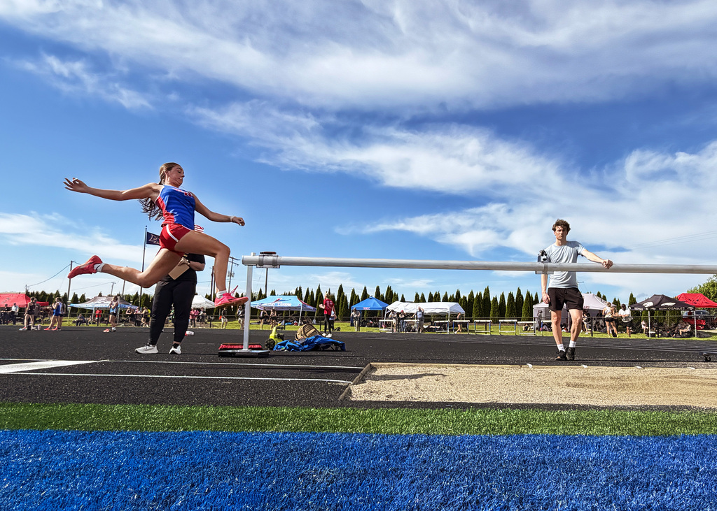 a girl jumping in the long jump pit