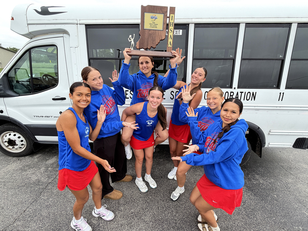 seven girls posing with a sectional trophy