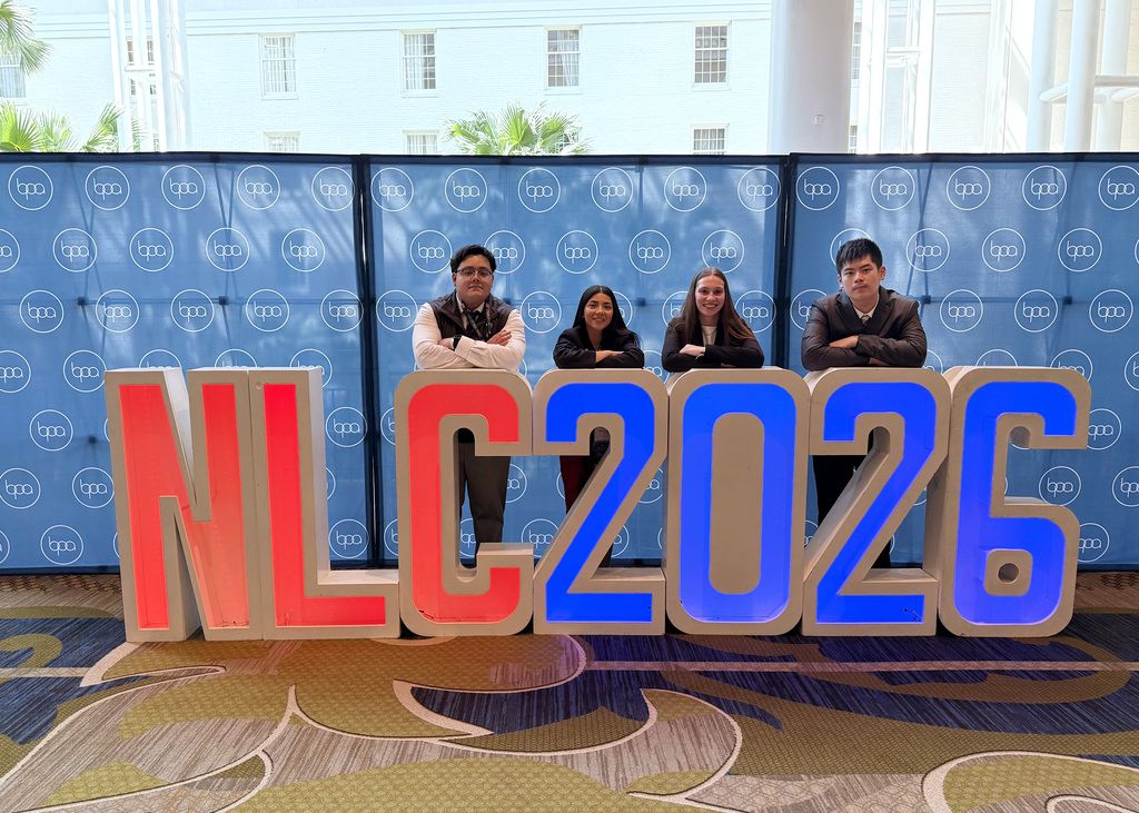 four people by a nlc sign