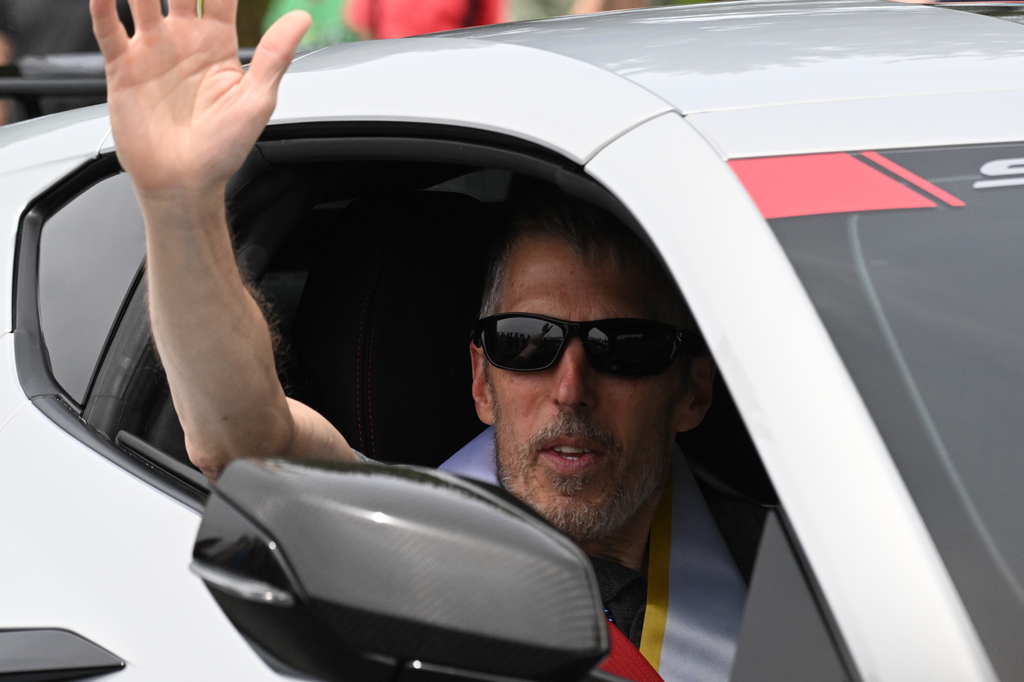 a man waving at people in the street
