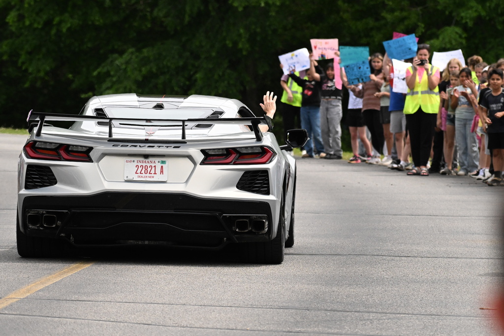a car driving down the lane with people watching
