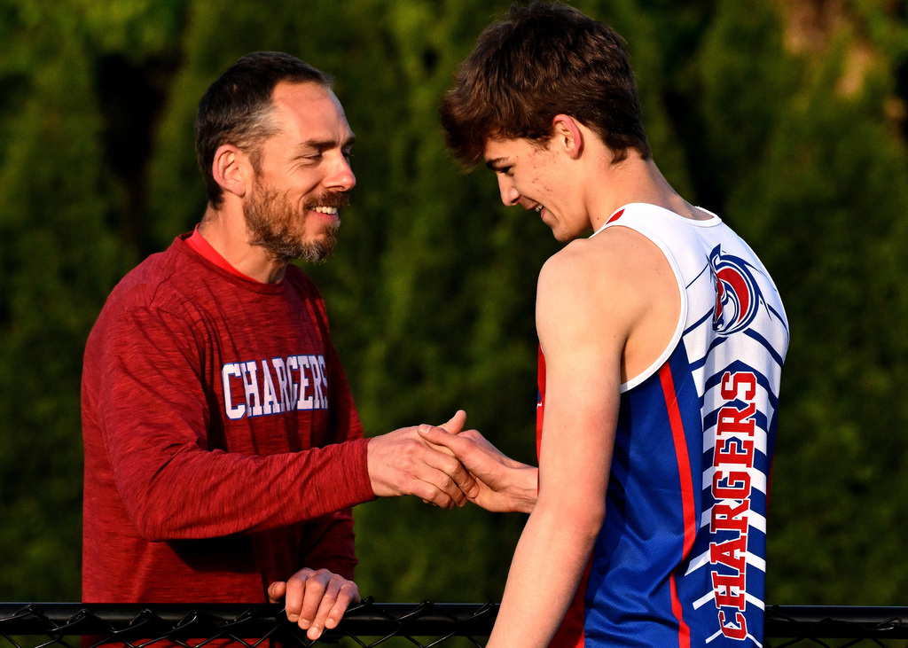 a track athlete congratulated by his coach