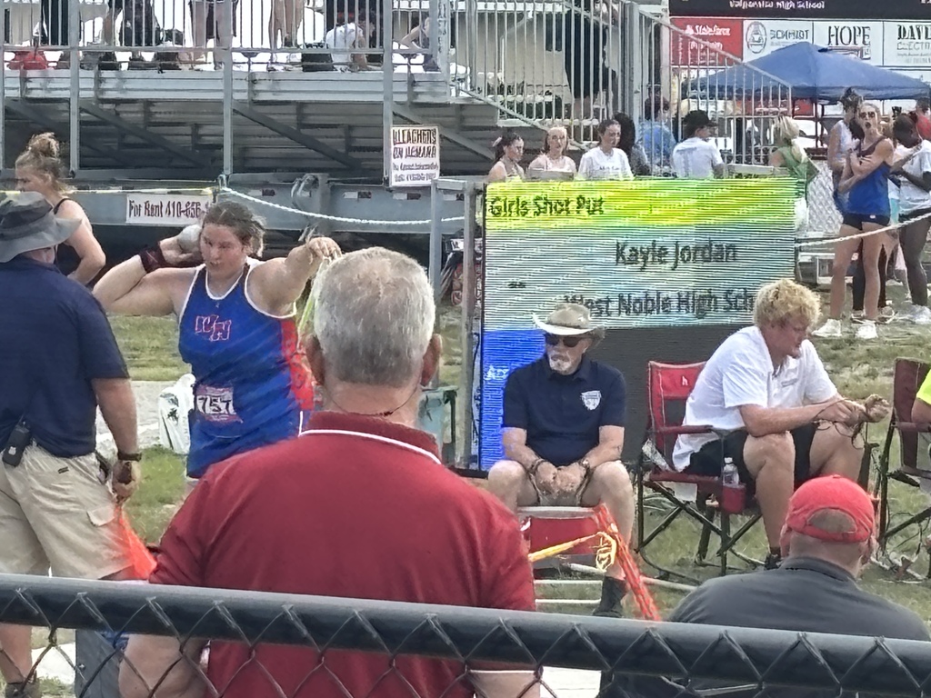 a track athlete preparing to throw a shot put