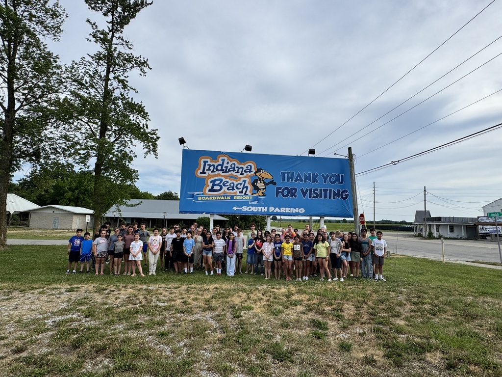 large group of kids in front of a sign