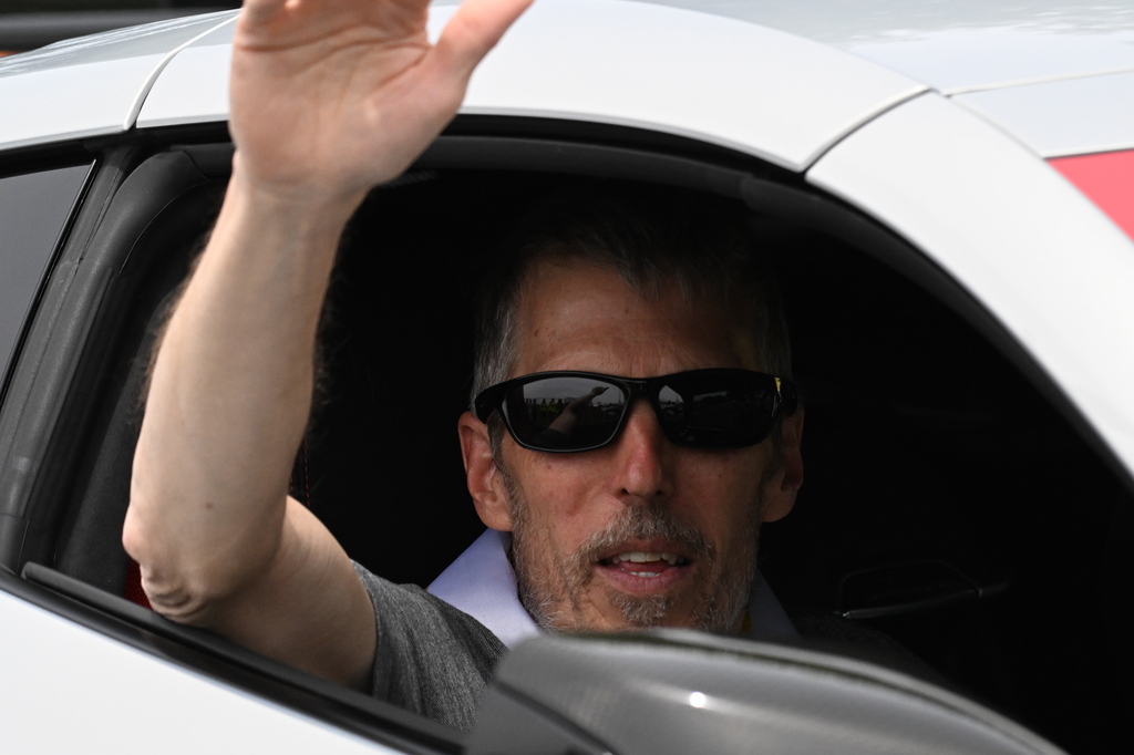 a man waving from a car