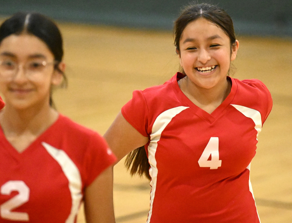 two girls in red jerseys smiling