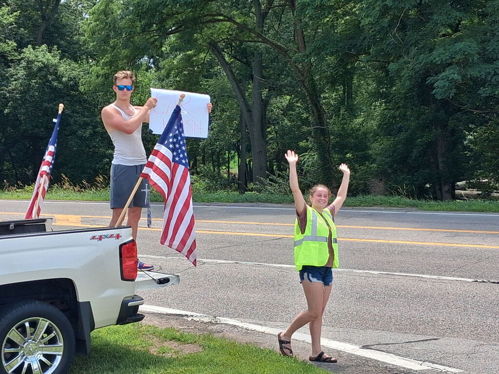 two people standing by the edge of the road