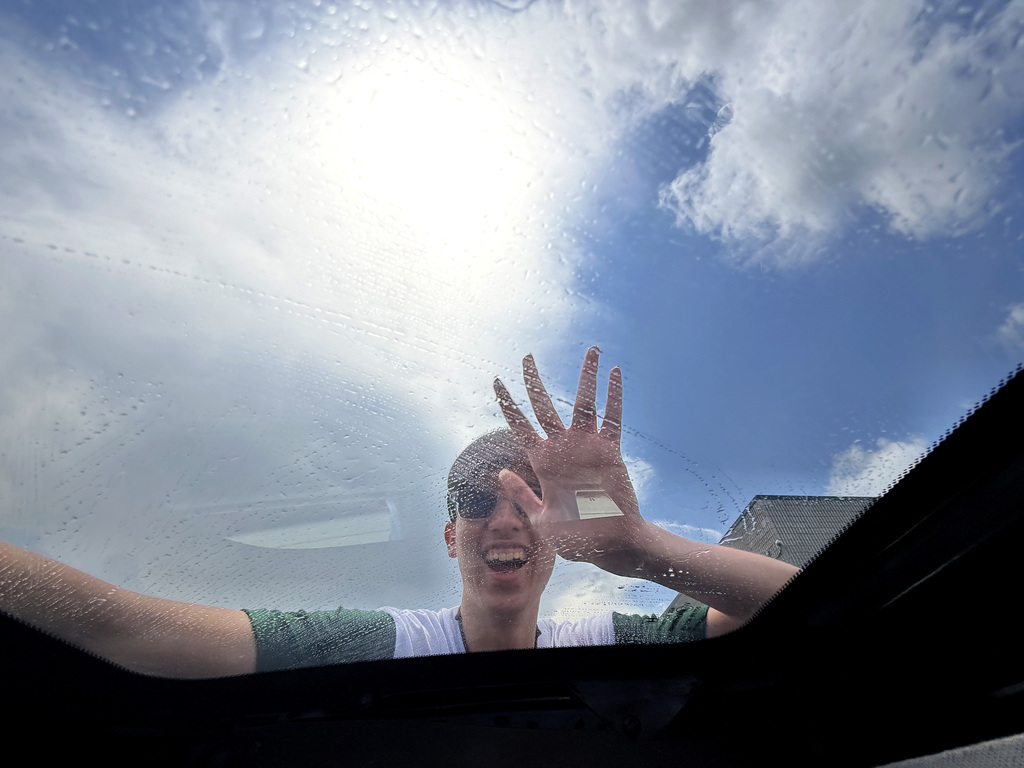 a young man washing washing a sun roof
