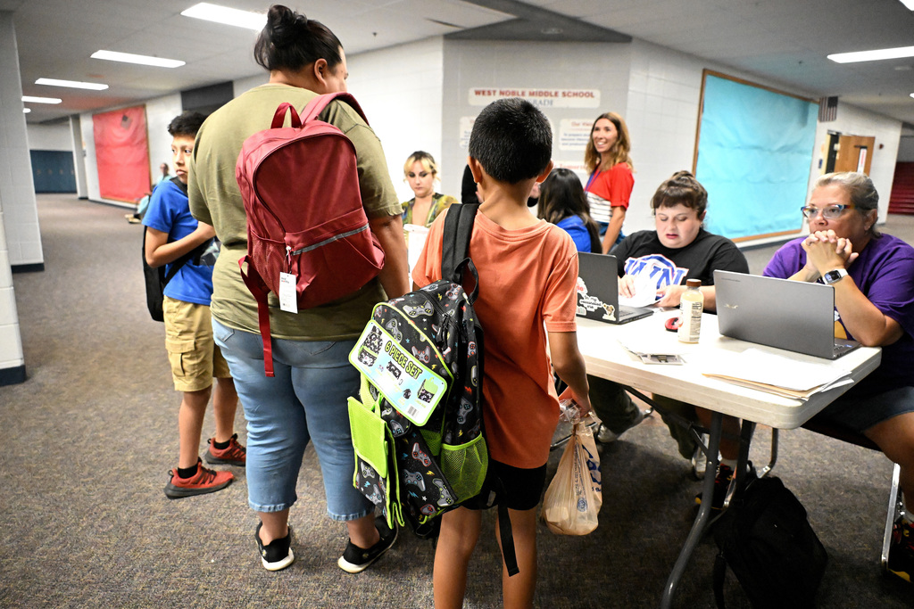 women and children talking to people sitting in chairs with computers