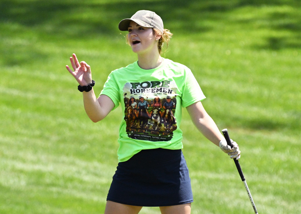 a girl celebrating her golf shot