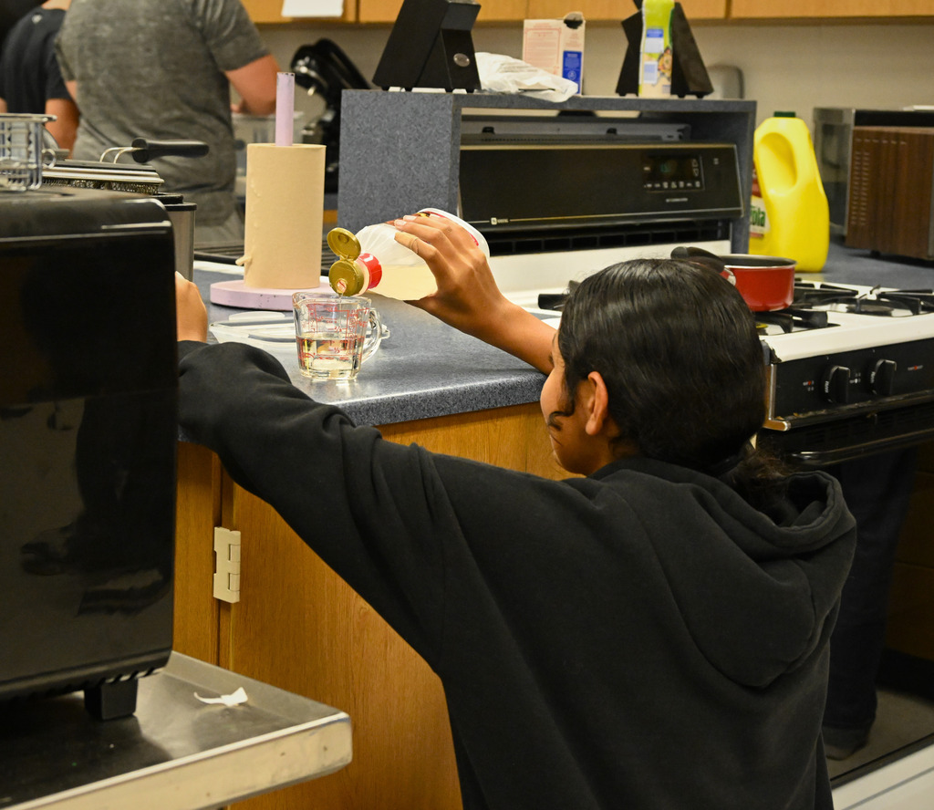 one student cooking in a kitchen