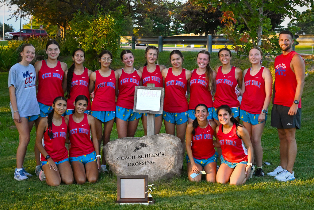 a team of girls in red shirts posing for a photo