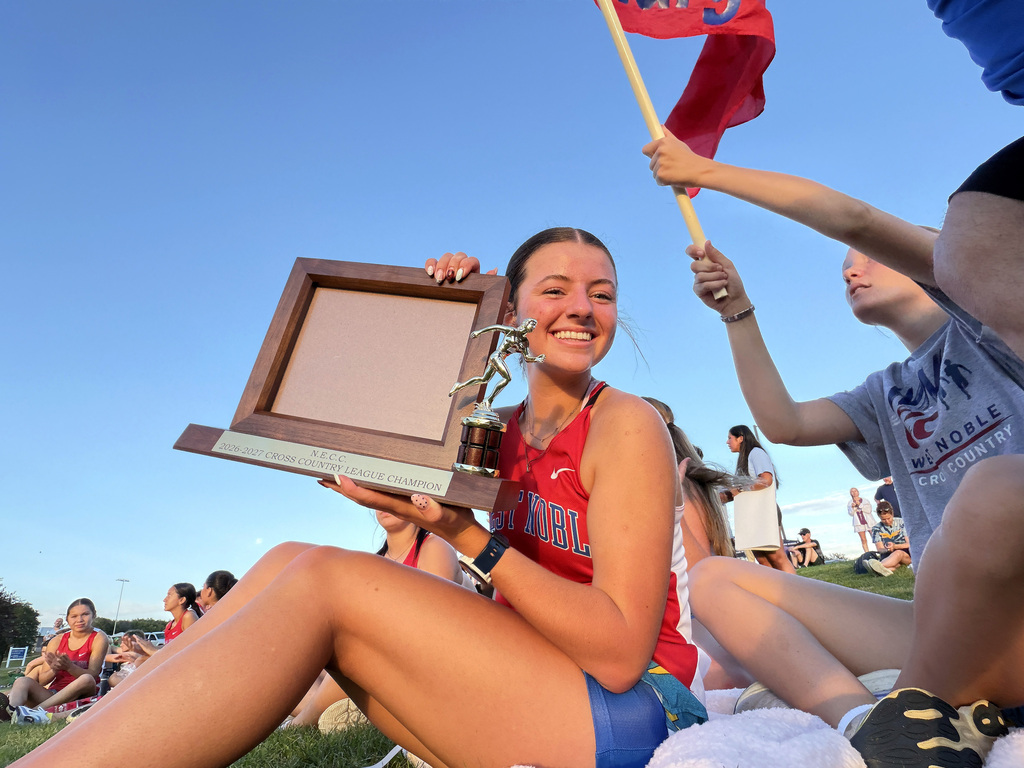 a girl in a red jersey holding a trophy