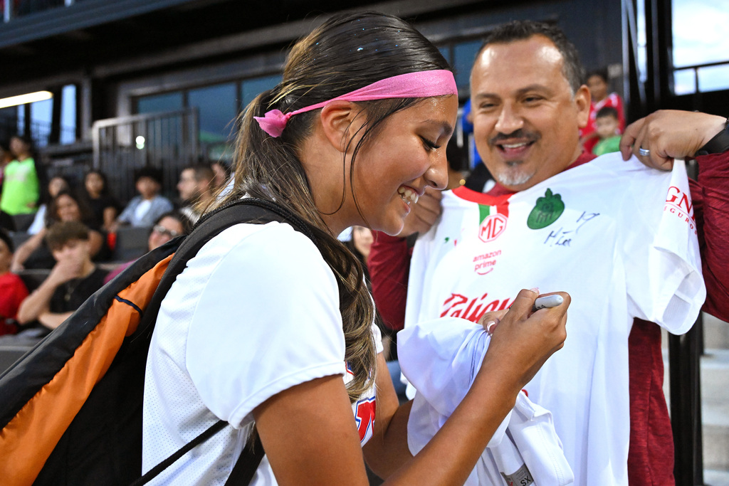 girl signing a jersey
