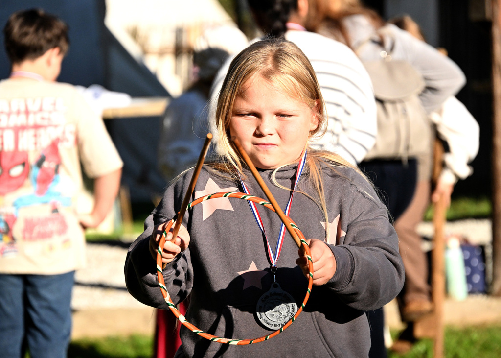 a girl in gray playing with a hoop