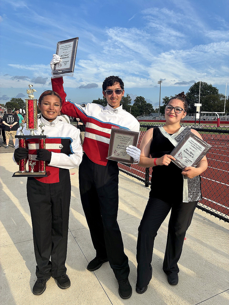 three people in the band holding awards