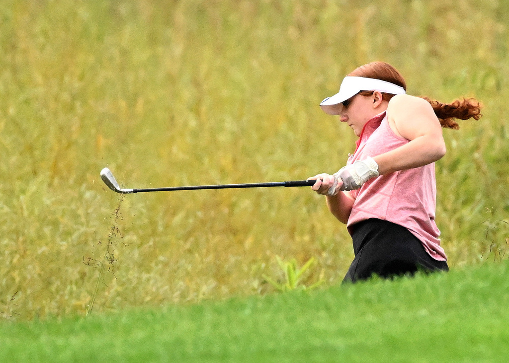 girl taking her golf shot