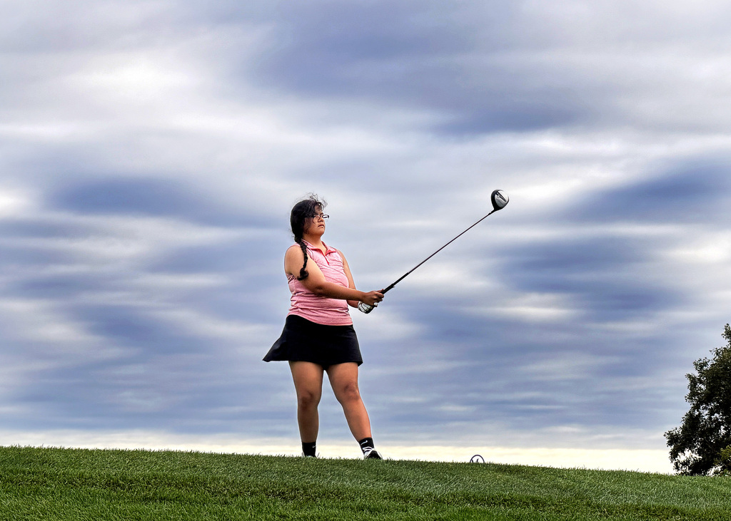 girl watching her golf shot