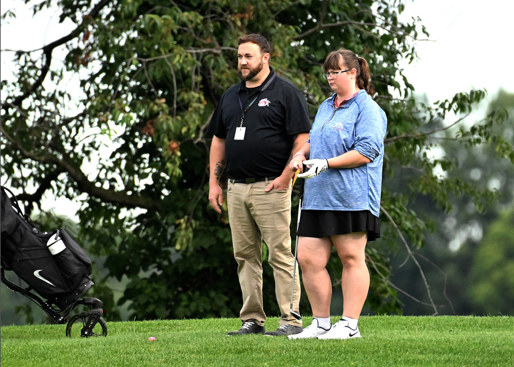 girl standing with her golf coach