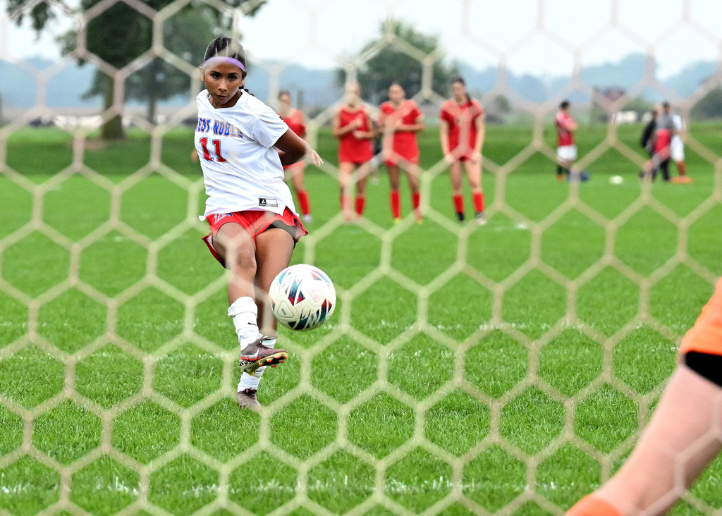 a girl kicking a soccer ball