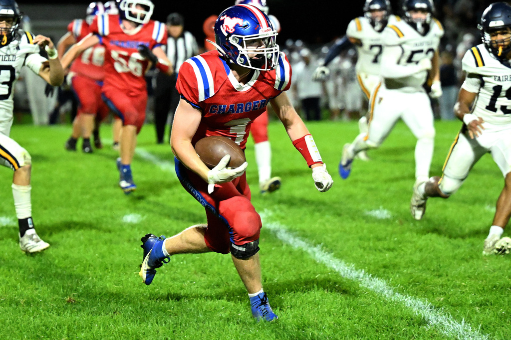 a football player in red carrying the ball