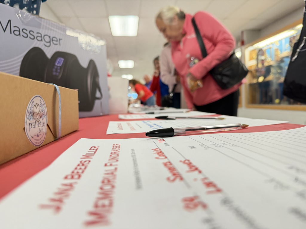 a woman looking at silent auction items