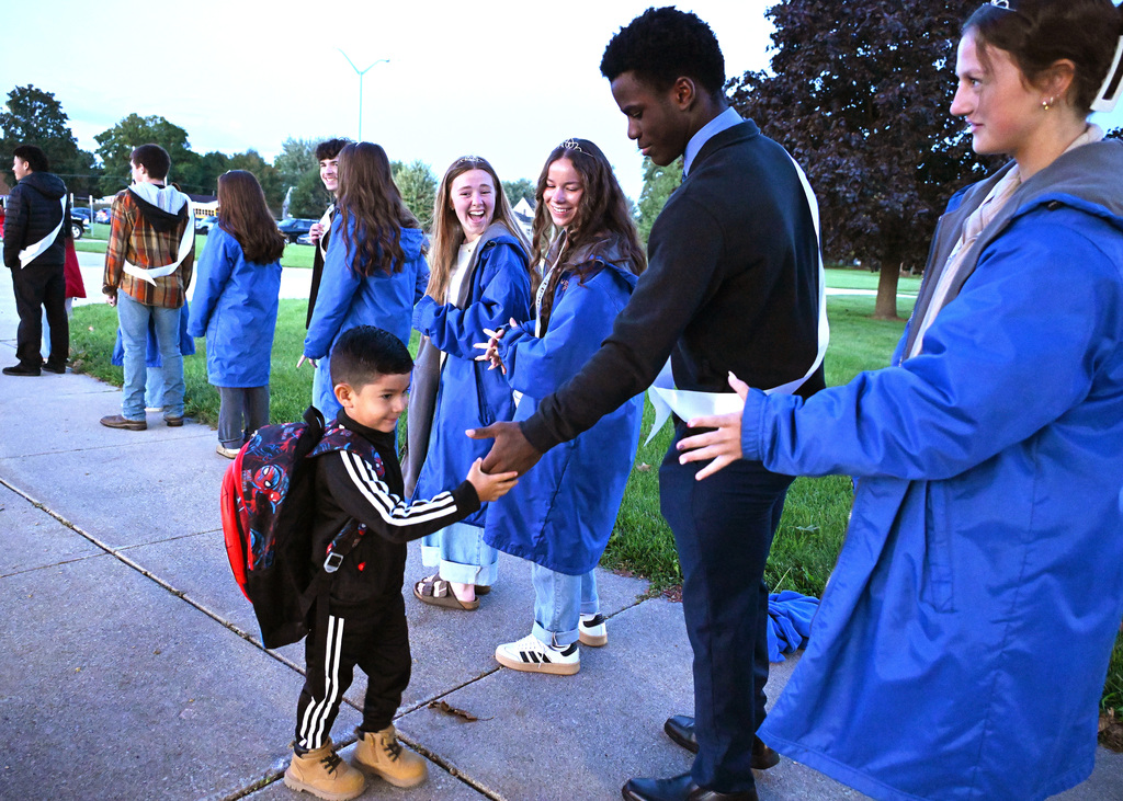little man hi fiving bigger students