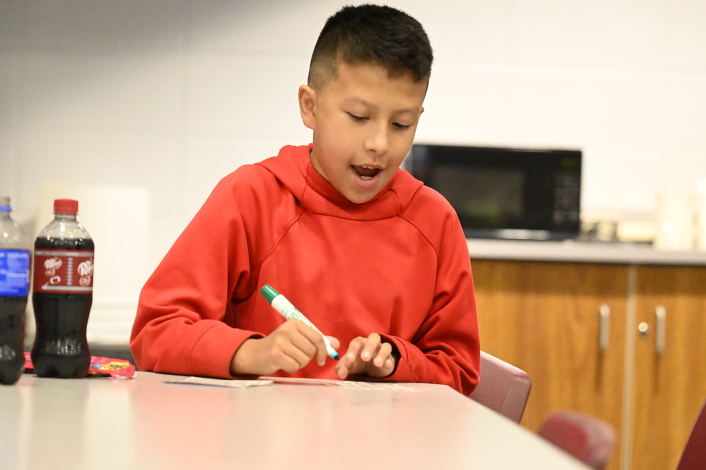 a student playing bingo in a red sweatshirt