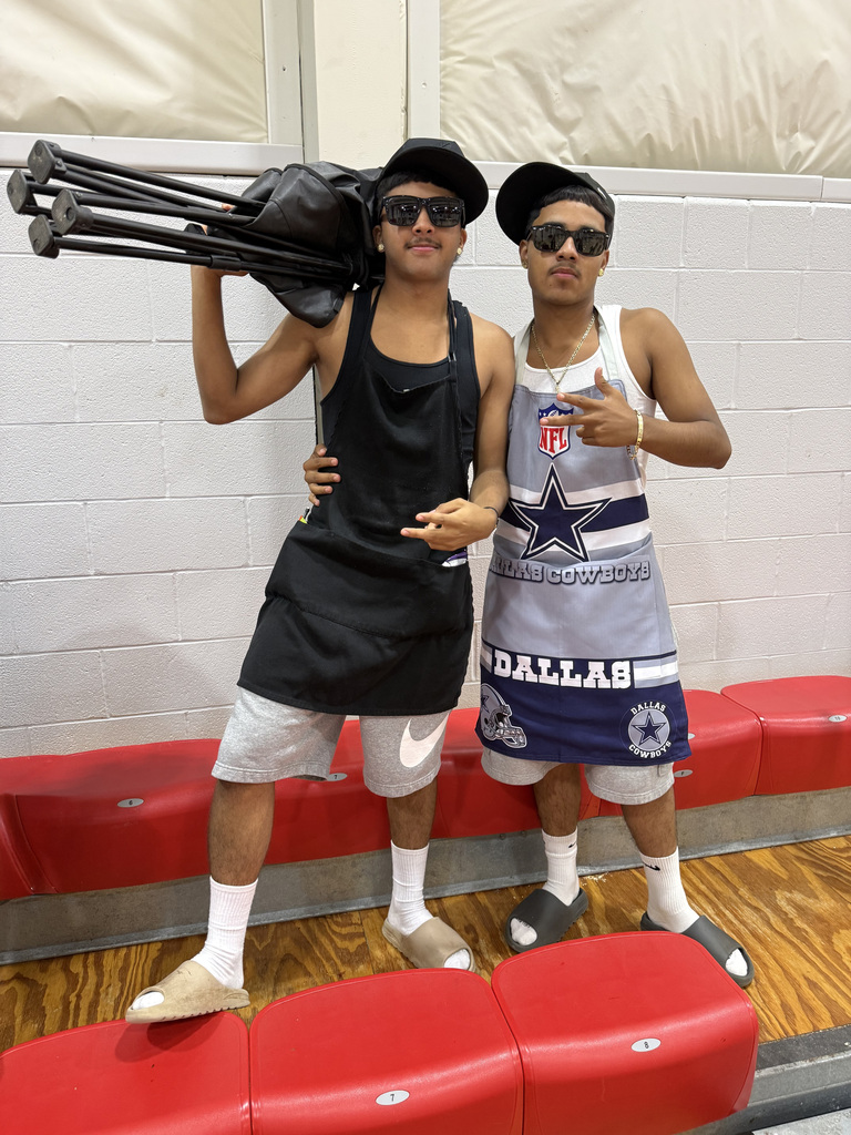 two students wearing shades and bbq vests