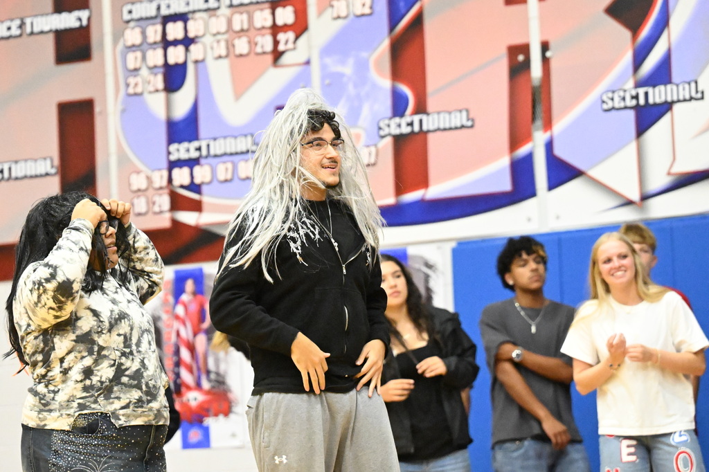 two students wearing wigs and smiling