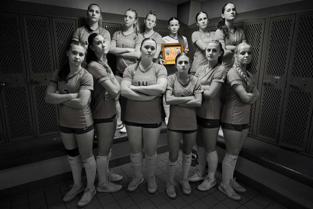 volleyball players posing with its trophy