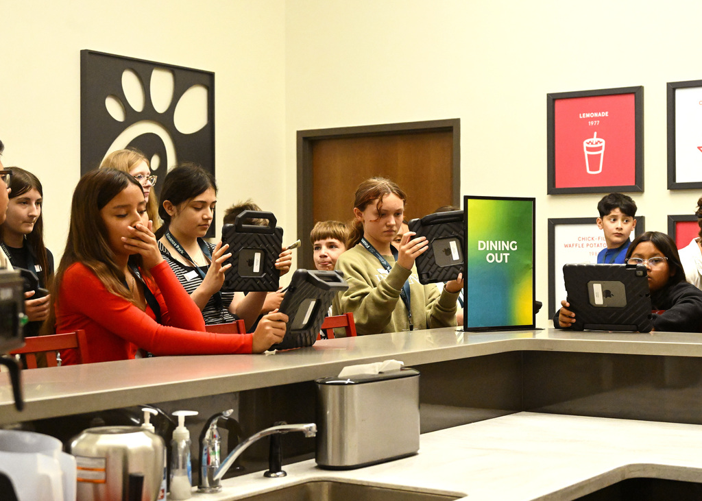 students working on tablets in a Chick Fil A