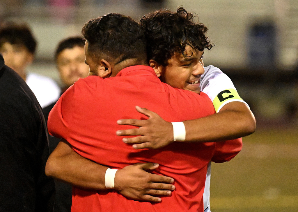 a coach and player hugging