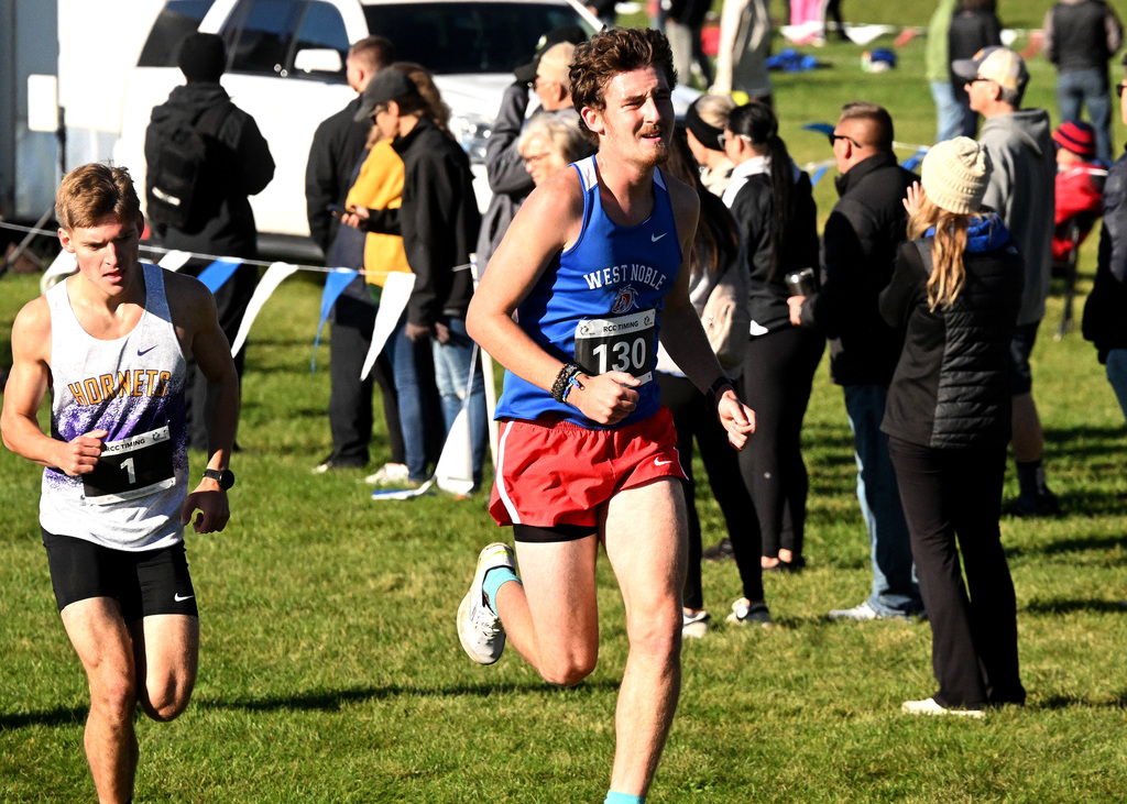 a boy running on a cross country course