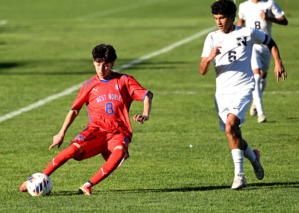 a soccer player in red shooting