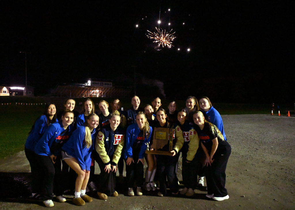 team posing with fireworks in the background