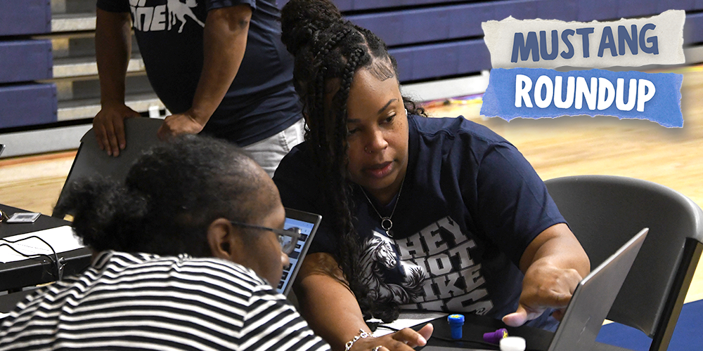 WOCCISD staff member helping woman with registration on a laptop