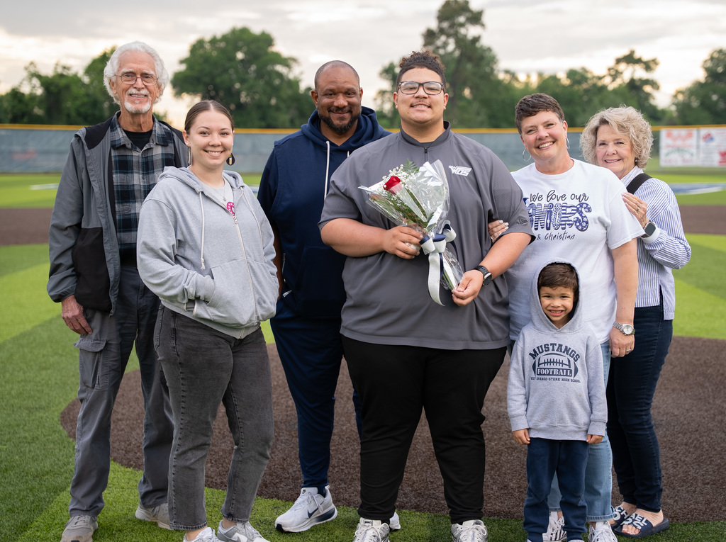 WOS senior standing with their family for baseball senior night