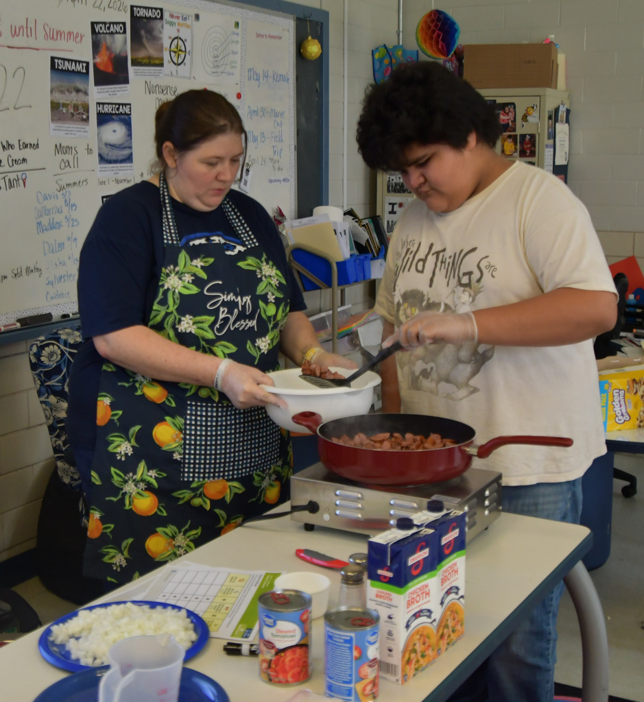 Student helping teacher make jambalaya