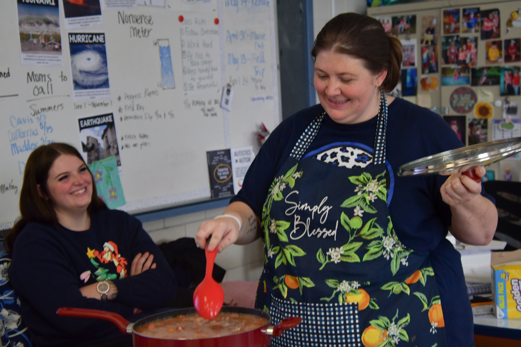 Teacher and assistant stirring a pot of jambalaya