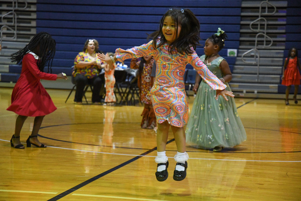 girl in disco attire jumping in the air