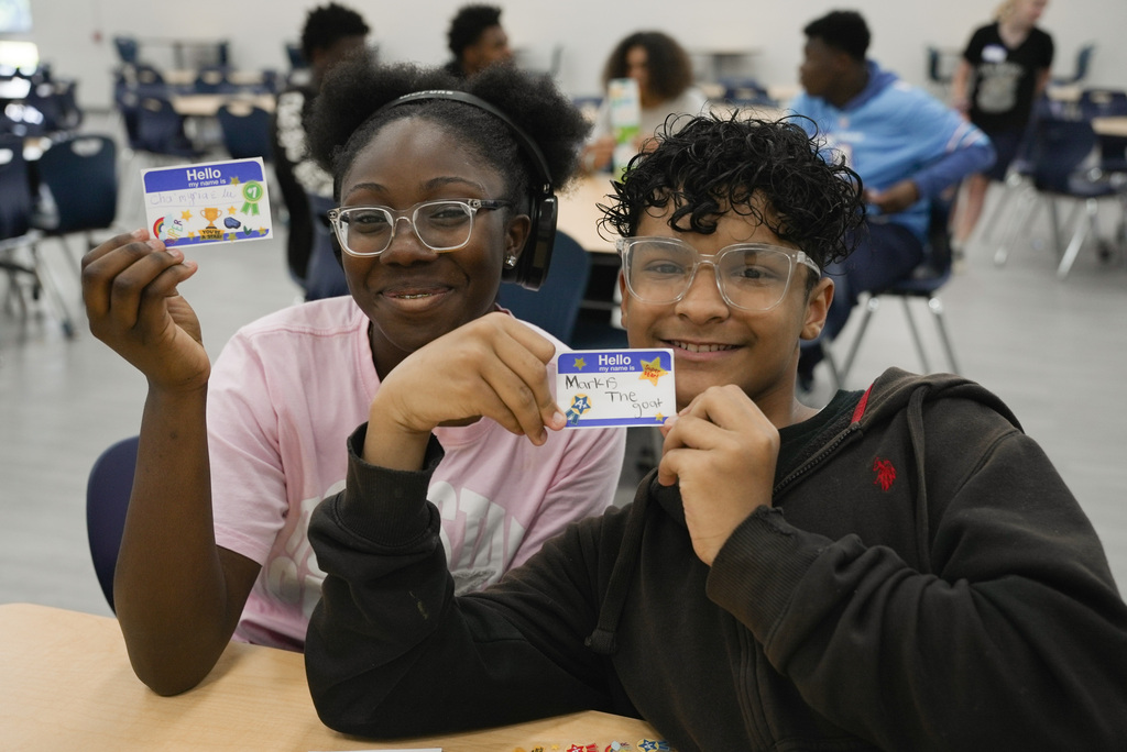 Kids happily holding up their name tag