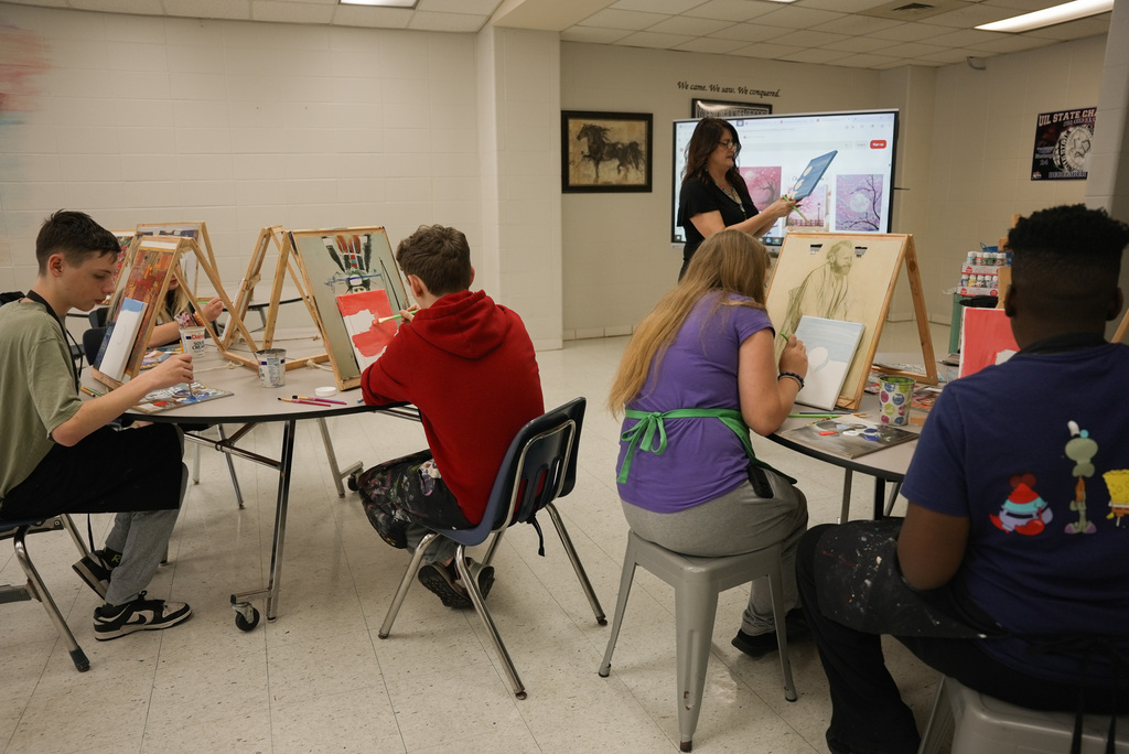 Students following teacher on steps on how to draw