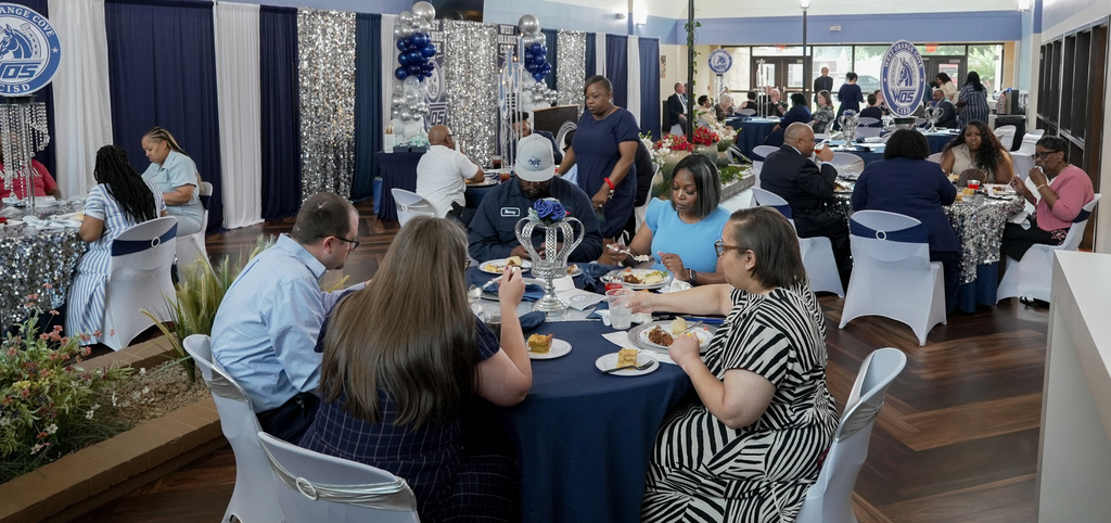 Attendees conversing and eating their food amongst their selves.