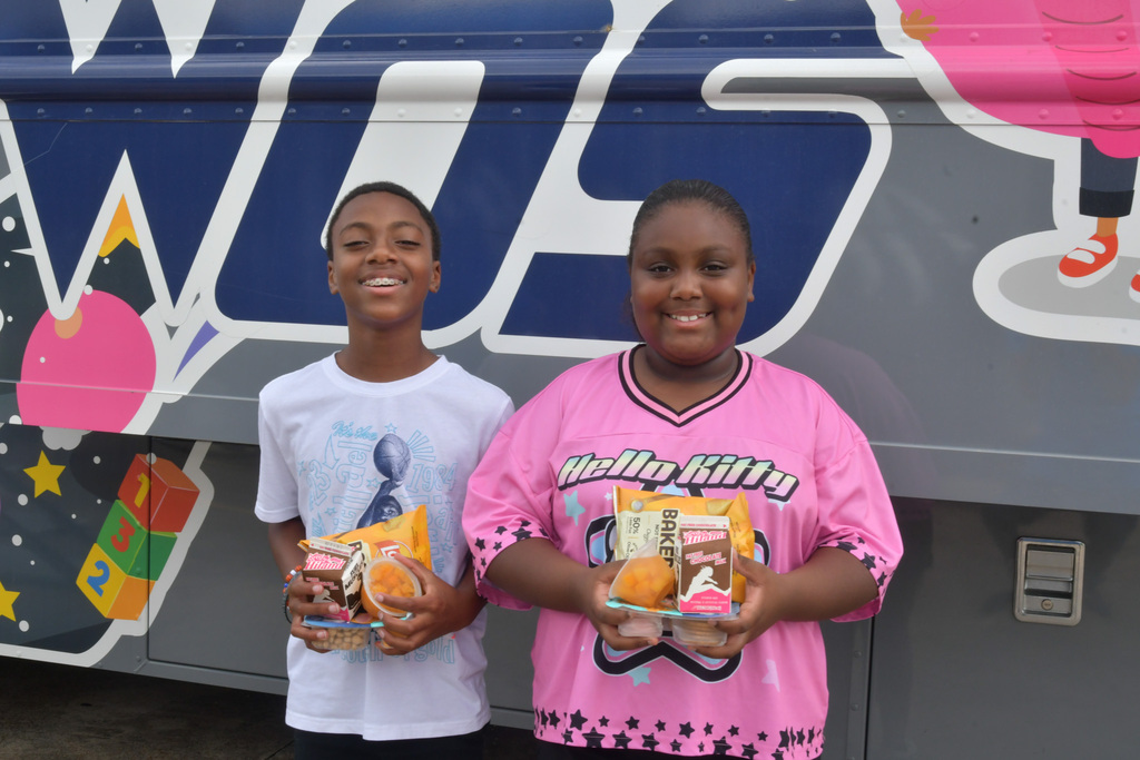 Students leaving with lunches in their hands from bus