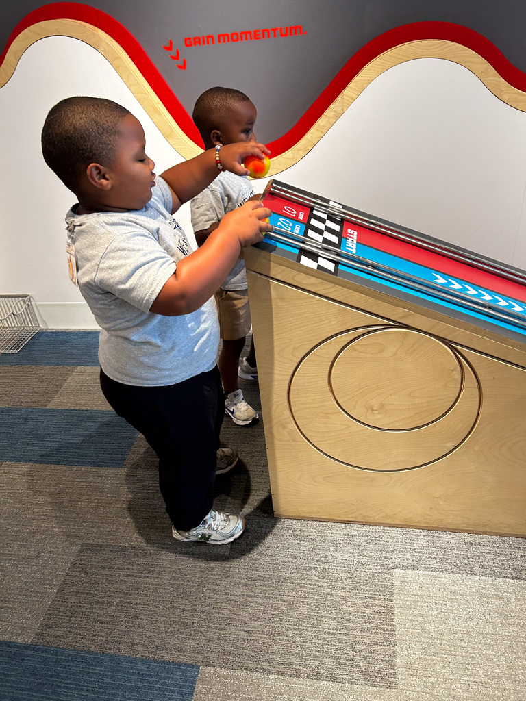 Students playing with a slot car exhibit