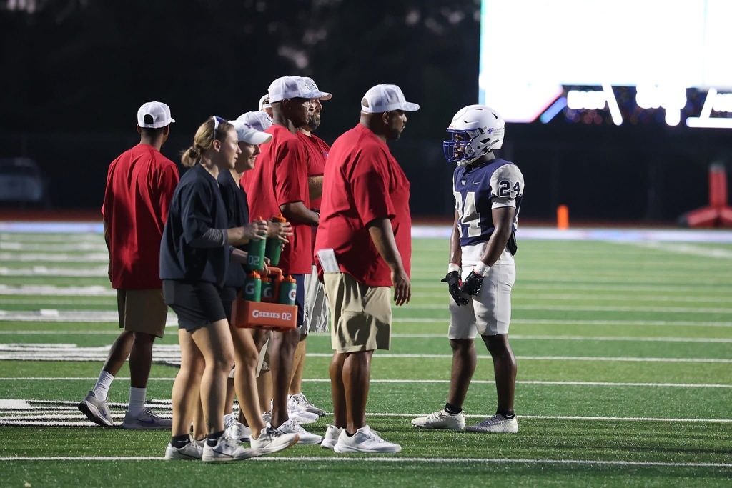 WOS Coaches talk to player on field
